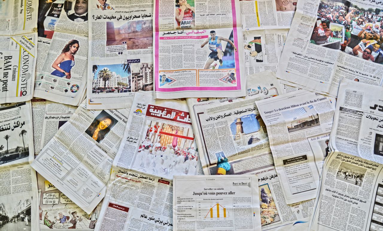 A vibrant array of newspapers laid out in Fès, showcasing diverse stories.